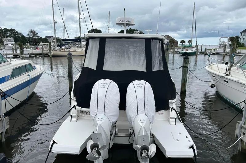 Slide: The Image of 2022 Regal 36 XO boat docked at marina with twin outboard engines. - 4