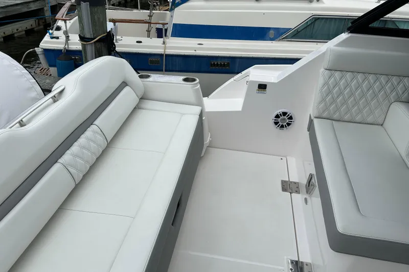 Slide: The Image of 2022 Regal 36 XO boat interior with white cushioned seating and speaker. - 6
