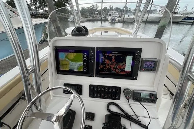 Slide: The Image of 2012 Jupiter 29 FS CC boat dashboard with navigation screens and controls at marina. - 11