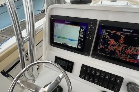 Slide: The Image of 2012 Jupiter 29 FS CC boat dashboard with Simrad navigation displays. - 12