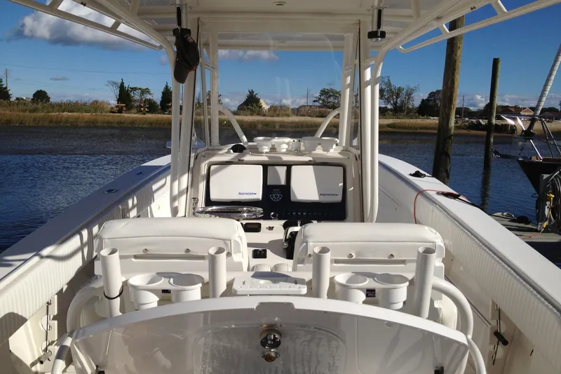 Slide: The Image of 2012 Jupiter 29 FS CC boat interior with fishing rod holders and navigation equipment. - 16