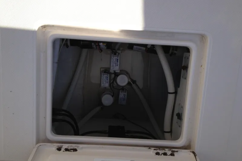 Slide: The Image of Access hatch of a 2012 Jupiter 29 FS CC boat, showing internal wiring and components. - 22