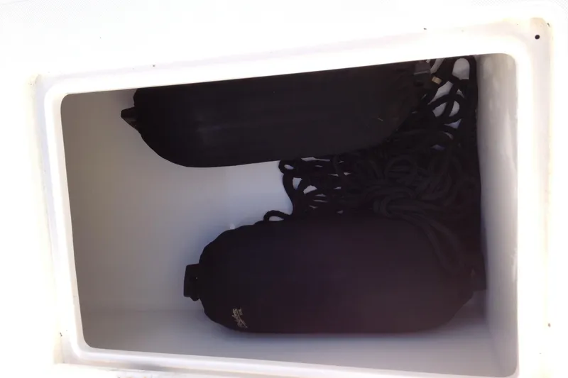 Slide: The Image of Storage compartment with black fenders and ropes on a 2012 Jupiter 29 FS CC boat. - 23