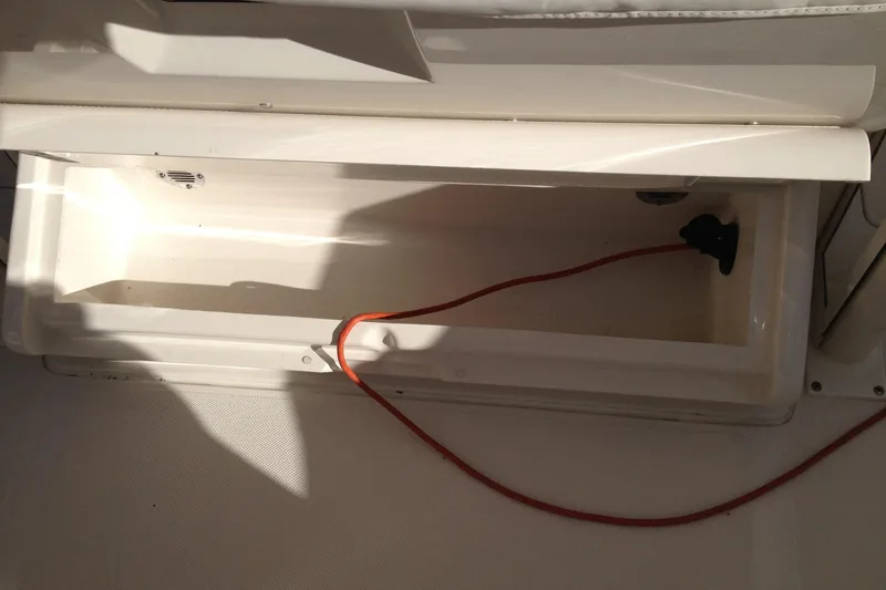 Slide: The Image of Open storage compartment in 2012 Jupiter 29 FS CC boat with red cable inside. - 25