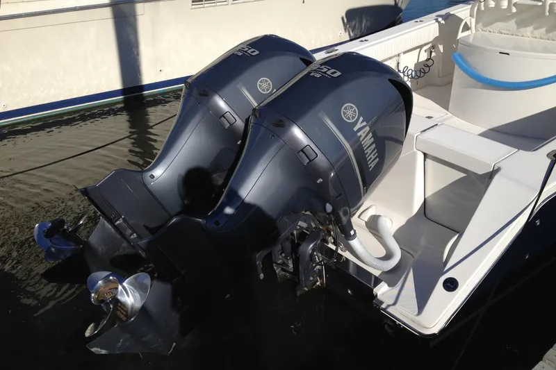 Slide: The Image of 2012 Jupiter 29 FS CC boat with dual Yamaha 150 engines docked in water. - 6