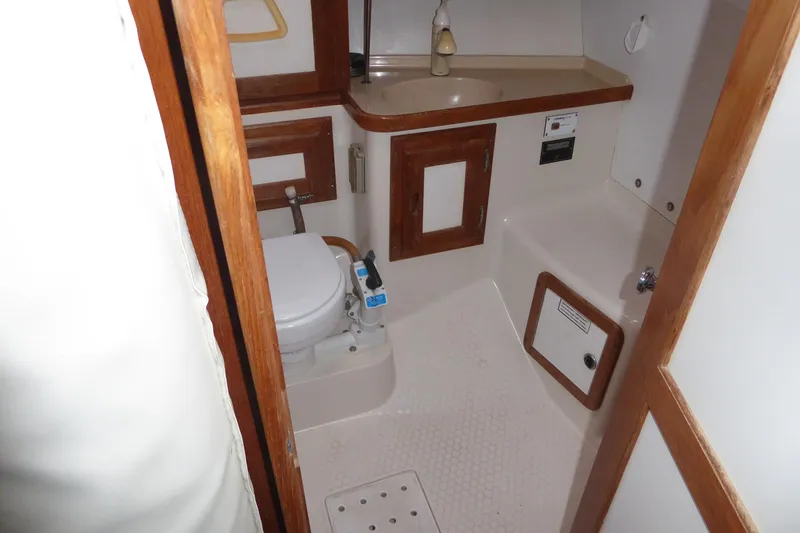 Slide: The Image of 1998 Catalina 36 MkII yacht bathroom with toilet, sink, and wooden cabinetry. - 16