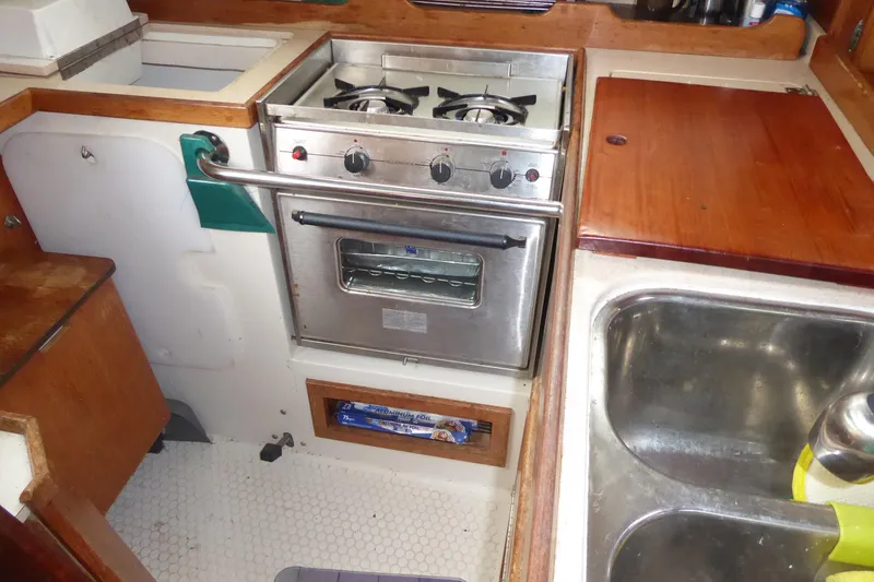 Slide: The Image of Compact kitchen area in a 1998 Catalina 36 MkII sailboat with stove and sink. - 19