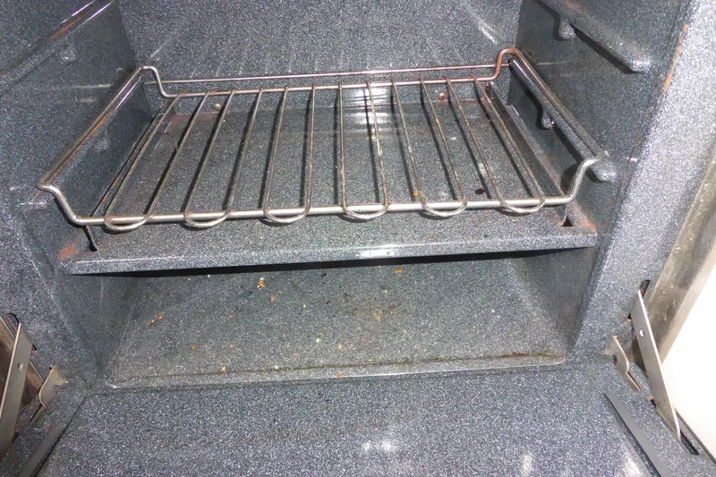 Slide: The Image of Empty oven interior with metal rack and visible crumbs. - 21