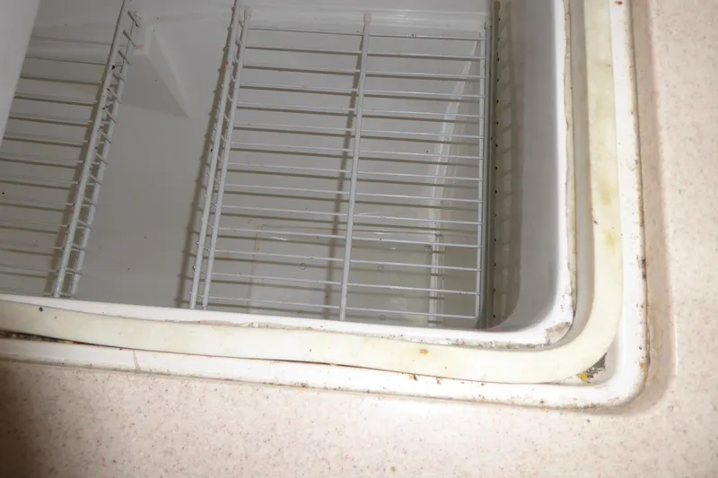 Slide: The Image of Interior view of a 1998 Catalina 36 MkII refrigerator compartment with wire shelves. - 24