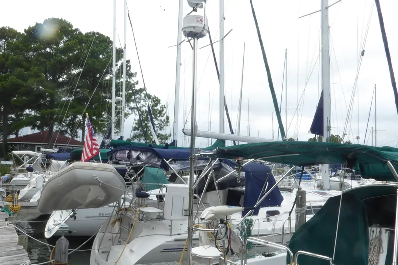 Slide: The Image of 1998 Catalina 36 MkII sailboat docked at marina with other vessels and trees in background. - 35