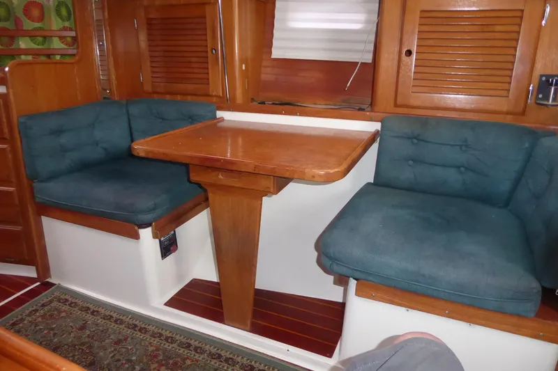Slide: The Image of Interior of a 1998 Catalina 36 MkII sailboat with cushioned seating and wooden table. - 7
