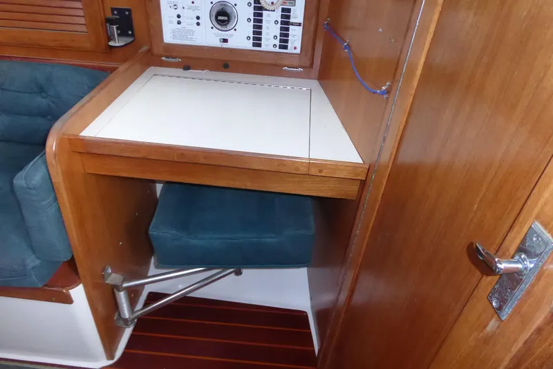 Slide: The Image of 1998 Catalina 36 MkII yacht interior with navigation station and foldable seat. - 9
