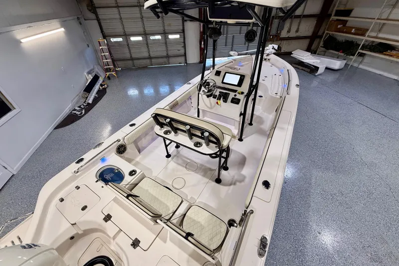 Slide: The Image of 2020 Sea Chaser 23 LX boat interior in a garage, featuring helm and seating. - 15