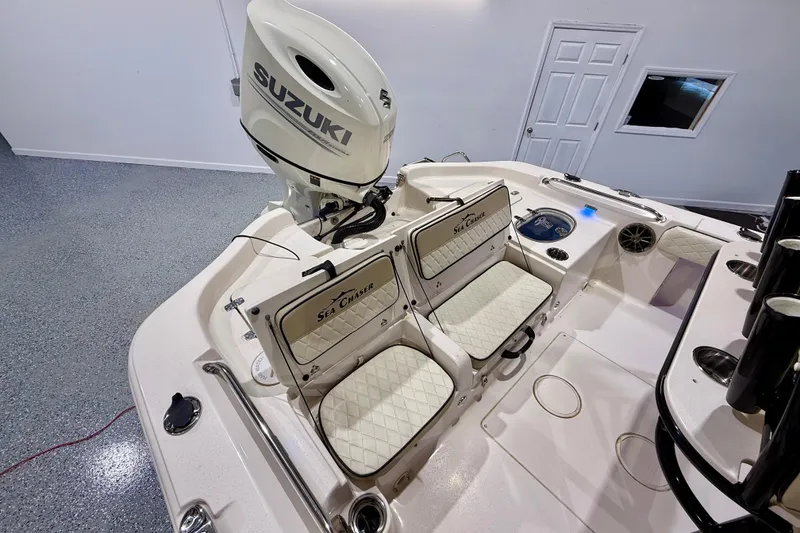 Slide: The Image of 2020 Sea Chaser 23 LX boat interior with Suzuki engine, featuring dual seats and storage. - 16