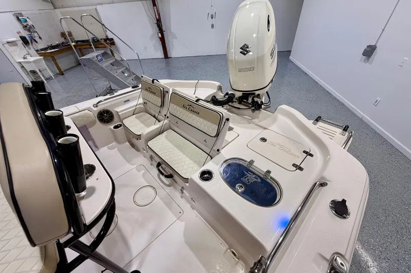 Slide: The Image of 2020 Sea Chaser 23 LX boat interior with Suzuki 200 engine, featuring seating and storage. - 18