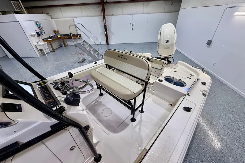 Slide: The Image of 2020 Sea Chaser 23 LX boat interior with seating and controls in a garage setting. - 19