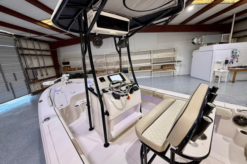 Slide: The Image of 2020 Sea Chaser 23 LX boat interior with steering console in a garage setting. - 20
