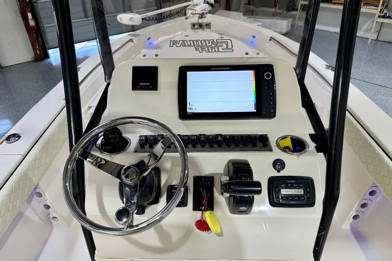 Slide: The Image of 2020 Sea Chaser 23 LX boat dashboard with steering wheel and navigation controls. - 23