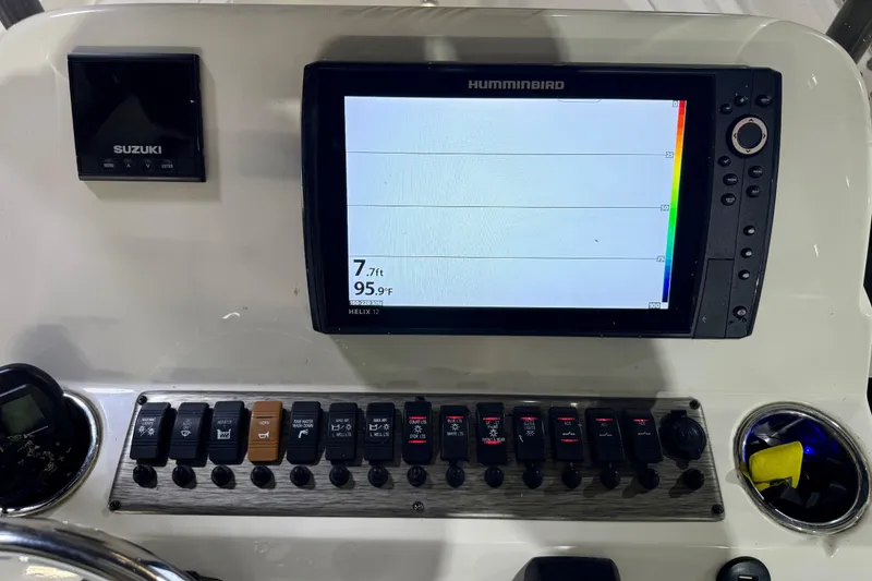 Slide: The Image of 2020 Sea Chaser 23 LX dashboard with Humminbird display and Suzuki controls. - 24