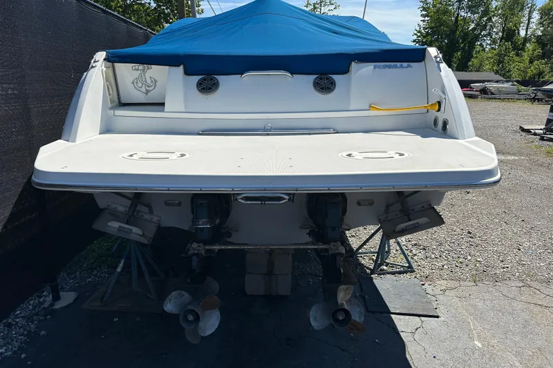 Slide: The Image of 1997 Formula 330 SS boat with blue cover, rear view showing propellers and swim platform. - 1