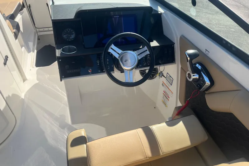 Slide: The Image of 2024 Sea Ray SDX 270 Outboard helm with steering wheel and control panel. - 14