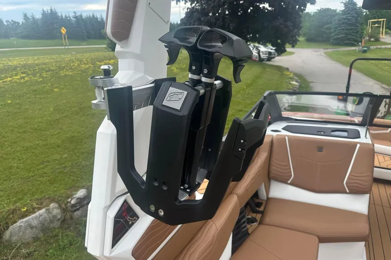 Slide: The Image of 2025 Nautique G23 boat interior with wakeboard rack and tan seating. - 13