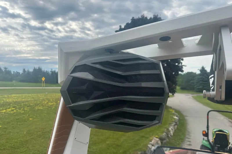 Slide: The Image of 2025 Nautique G23 boat speaker against a cloudy sky and green landscape. - 14