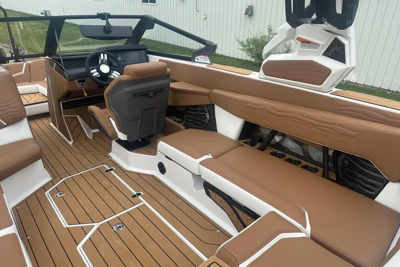Slide: The Image of 2025 Nautique G23 boat interior with brown leather seating and modern dashboard design. - 20