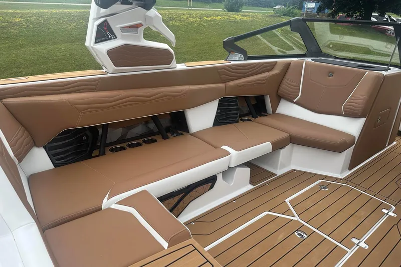 Slide: The Image of 2025 Nautique G23 boat interior with brown leather seating and teak flooring. - 21