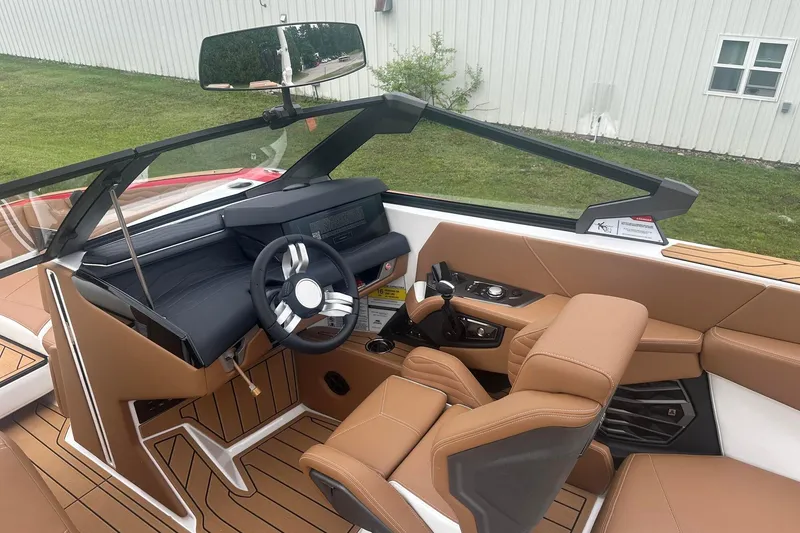 Slide: The Image of 2025 Nautique G23 boat interior with modern dashboard and tan leather seating. - 28