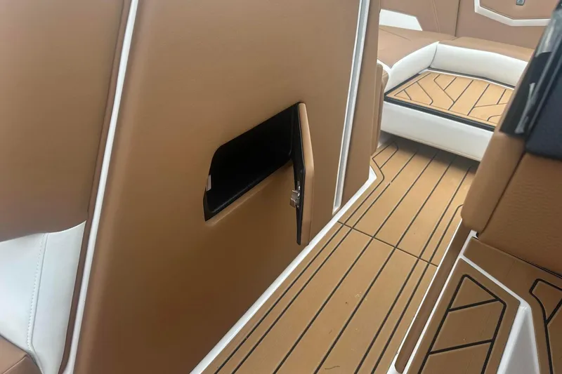 Slide: The Image of 2025 Nautique G23 interior with tan and white seating, featuring sleek design and wood-patterned flooring. - 32