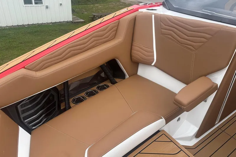 Slide: The Image of 2025 Nautique G23 boat interior with tan leather seating and cup holders. - 38