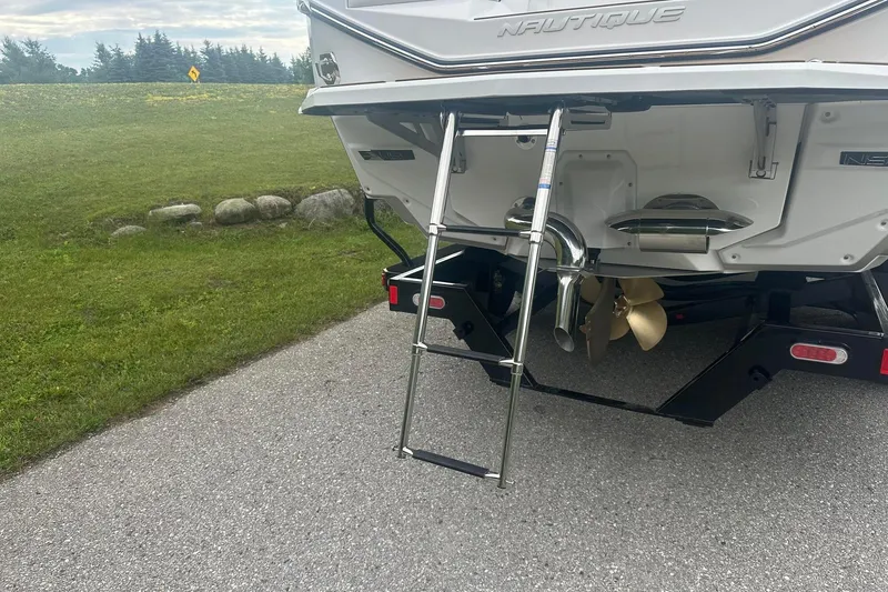 Slide: The Image of 2025 Nautique G23 boat rear view with ladder and propeller on a trailer. - 5