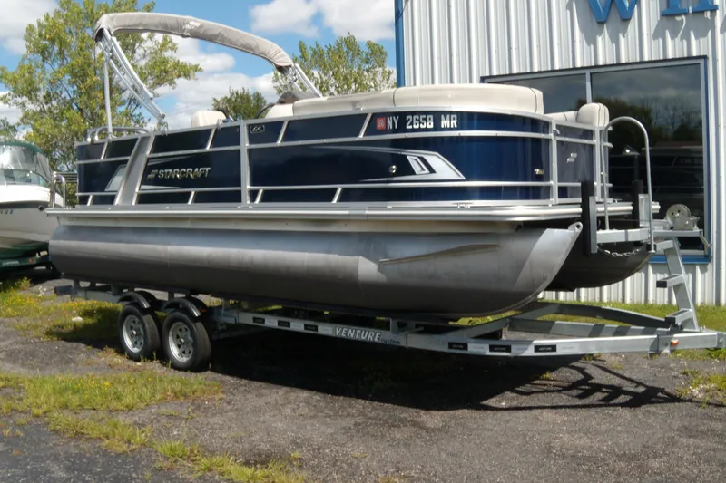 The Image of 2020 Starcraft EX 20 C pontoon boat on trailer, parked outdoors. - 0