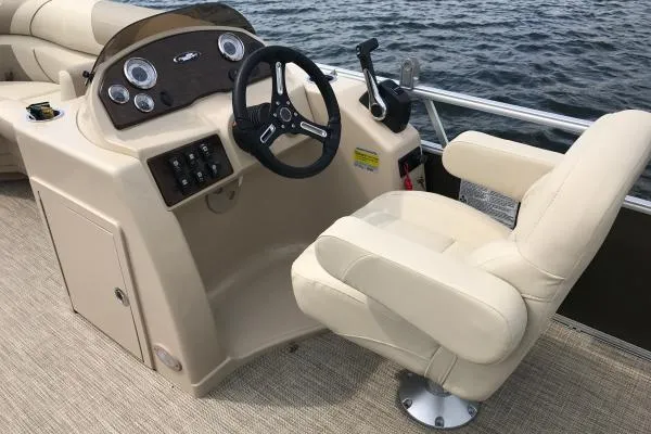 Slide: The Image of Manufacturer Provided Image: 2020 Starcraft EX 20 C boat helm with beige captain's chair and steering wheel. - 24