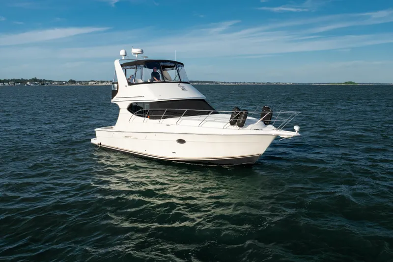 Slide: The Image of 2005 Silverton 34 Convertible yacht cruising on open water under clear skies. - 0
