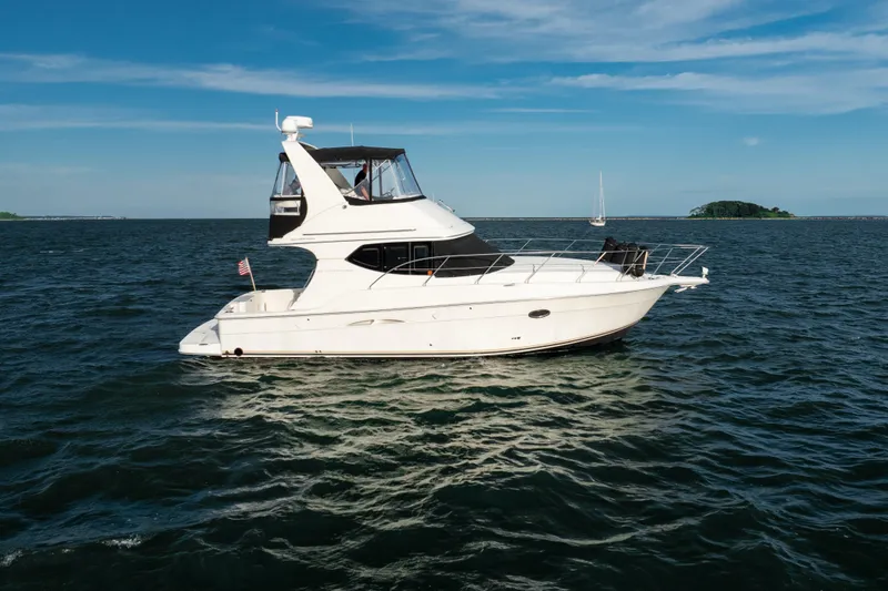 Slide: The Image of 2005 Silverton 34 Convertible yacht cruising on open water under clear blue skies. - 1