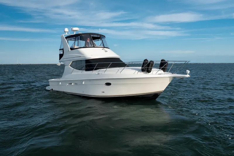 Slide: The Image of 2005 Silverton 34 Convertible yacht cruising on open water under a clear blue sky. - 10