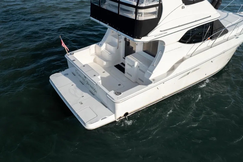 Slide: The Image of 2005 Silverton 34 Convertible yacht on water, rear view with American flag. - 12