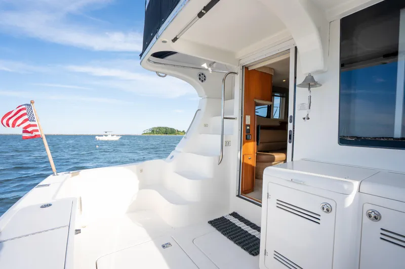 Slide: The Image of 2005 Silverton 34 Convertible yacht deck with American flag, open sea view. - 13