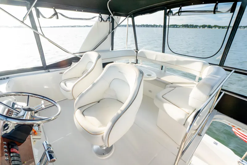 Slide: The Image of Luxurious interior of 2005 Silverton 34 Convertible yacht with plush seating and steering wheel. - 19