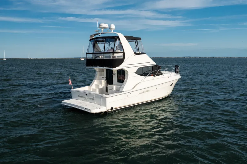 Slide: The Image of 2005 Silverton 34 Convertible yacht on open water under a clear blue sky. - 2