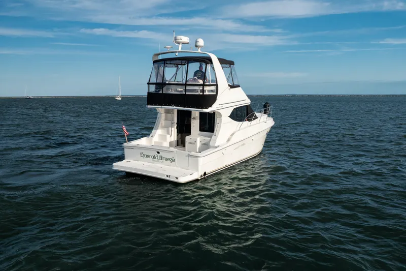 Slide: The Image of 2005 Silverton 34 Convertible yacht cruising on open water under a clear blue sky. - 3