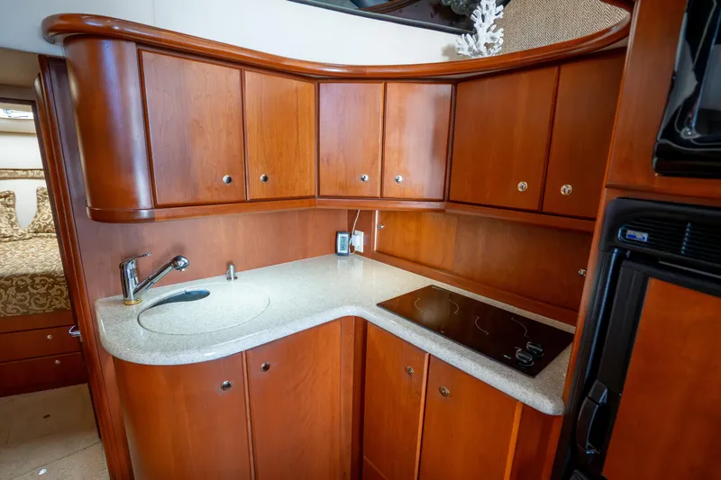 Slide: The Image of Luxurious 2005 Silverton 34 Convertible yacht kitchen with wood cabinetry and modern appliances. - 31