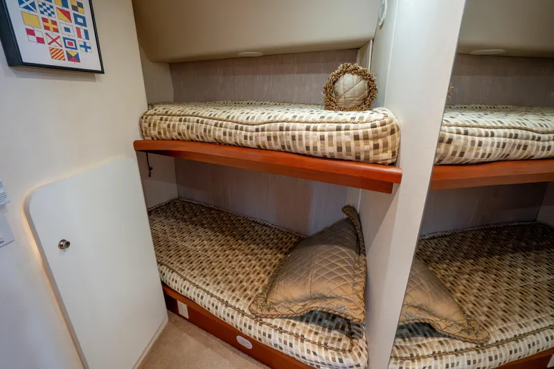 Slide: The Image of 2005 Silverton 34 Convertible yacht interior with cozy twin bunk beds and nautical decor. - 32
