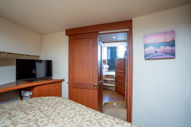 Slide: The Image of Interior of 2005 Silverton 34 Convertible yacht bedroom with TV and wooden door. - 34