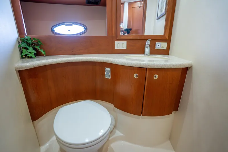 Slide: The Image of 2005 Silverton 34 Convertible yacht bathroom with wooden cabinetry and oval window. - 36