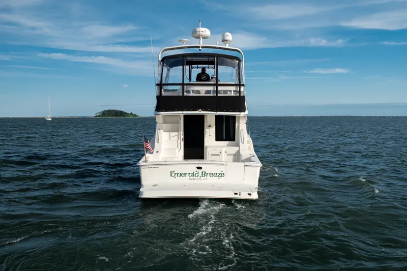 Slide: The Image of 2005 Silverton 34 Convertible boat named "Emerald Breeze" cruising on open water. - 4