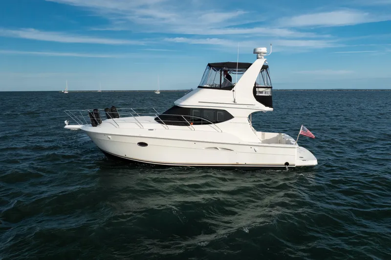 Slide: The Image of 2005 Silverton 34 Convertible yacht cruising on open water under a clear blue sky. - 5