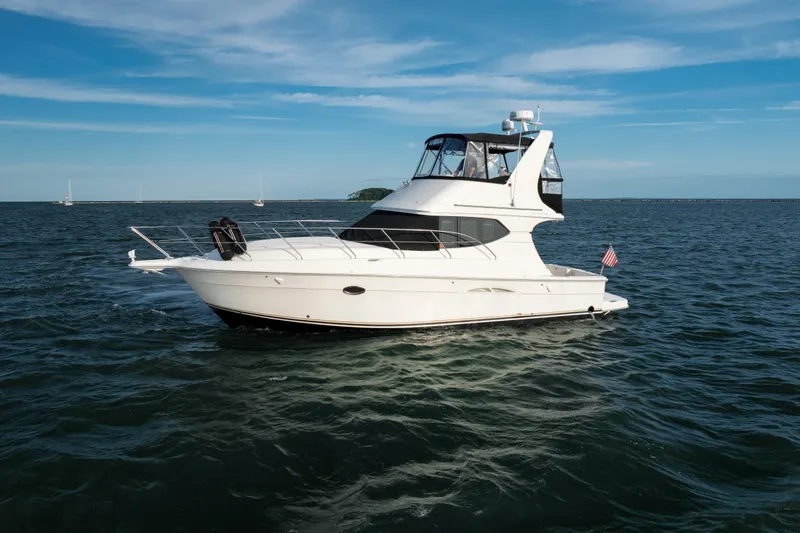 Slide: The Image of 2005 Silverton 34 Convertible yacht cruising on open water under a clear blue sky. - 6